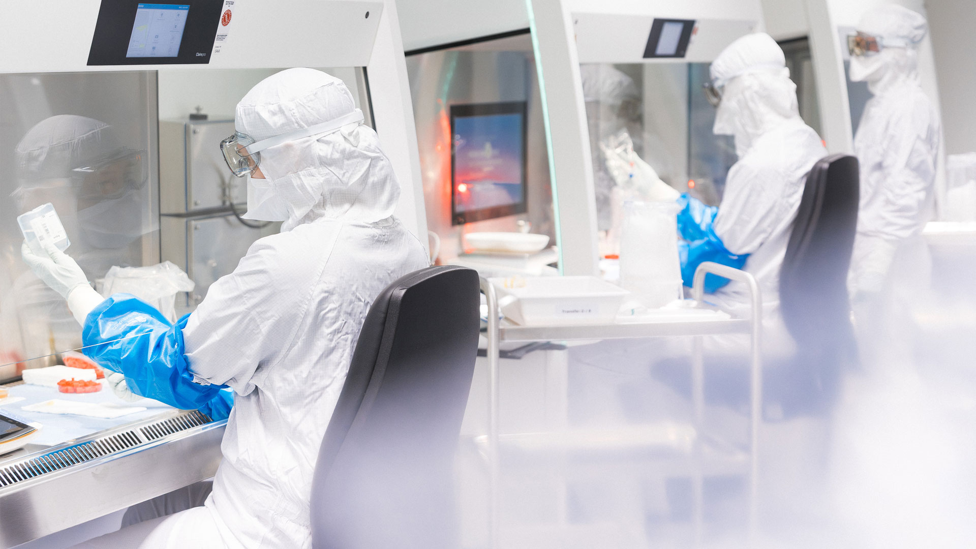 Zwei Mitarbeiter in Schutzkleidung bei der Arbeit im Reinraum